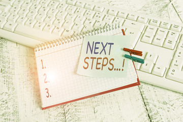 Handwriting text Next Steps. Conceptual photo something you do after you have finished doing first one notebook paper reminder clothespin pinned sheet white keyboard light wooden