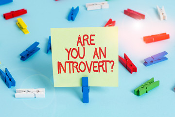 Word writing text Are You An Introvertquestion. Business photo showcasing demonstrating who tends to turn inward mentally Colored clothespin papers empty reminder blue floor background office pin