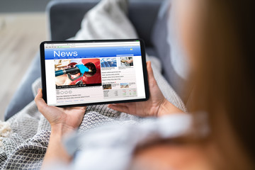 Person Watching News On Digital Tablet