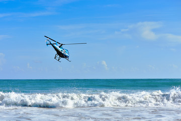 Fototapeta na wymiar Macao beach. Dominican Republic October 7, 2015. An excursion helicopter takes off over the beautiful Caribbean coast