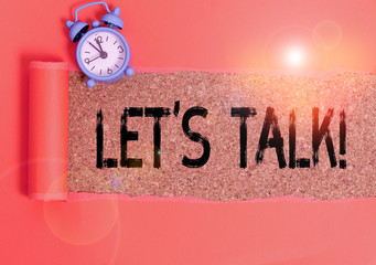 Conceptual hand writing showing Let S Talk. Concept meaning they are suggesting beginning conversation on specific topic Alarm clock and torn cardboard on a wooden classic table backdrop