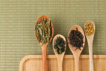 green tea leaves on wooden spoon