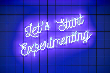 Handwritten neon glowing text Lets Start Experimenting on blue tiled wall. Trendy classic color. Luminescent illuminated lamp
