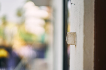 The switch on the wall close-up. White light switch on a concrete wall