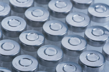 Glass medical ampoule vial for injection. Medicine is dry white drug penicillin powder or liquid with of aqueous solution in ampulla. Close up. Bottles ampule with aluminum cap on backgrounds gray.