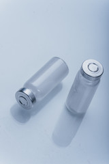 Glass medical ampoule vial for injection. Medicine is dry white drug penicillin powder or liquid with of aqueous solution in ampulla. Close up. Bottles ampule with aluminum cap on backgrounds gray.