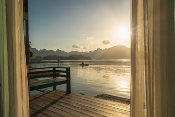 a man kayaking in the lake with beautiful sunrise