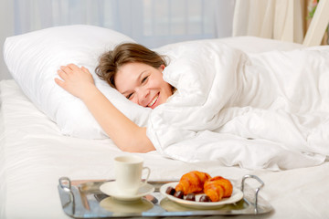 Obraz na płótnie Canvas Breakfast on a tray beside the bed sleeping girl