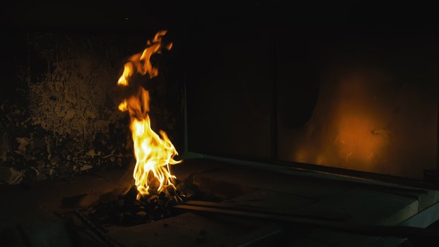 Forge fire in furnace. Blacksmith tempers a steel product in a stove. Smithy forging for hardening and heating iron. Blacksmith makes iron for manufacture of fireplace, stove. Burner Slow Motion.