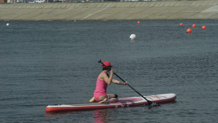 Athlete on stand up paddleboard sup holding paddle board up in air in success on paddleboarding...
