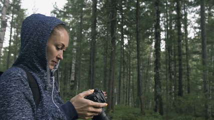 Traveler photographing scenic view in forest. One caucasian woman shooting nice magic look. Girl take photo video on dslr mirrorless camera. Professional photographer travel with backpack. Outdoor.