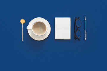 Classic Blue. Color of the Year 2020. Top view of workspace with laptop, succulent, glasses, coffee and copy space on colored blue background. Flatlay minimalism