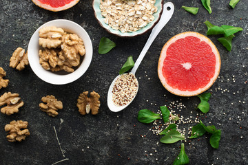 Ingredients for a healthy breakfast, nuts, oatmeal, honey, berries, fruits, blueberry, orange, pomegranate seeds, almonds, walnuts. The concept of natural organic food in season. Top view