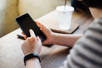 Girl pointing finger on screen smartphone on background wooden floor