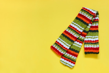 top view colorful knitted scarf isolated on yellow background, copy space, flat lay