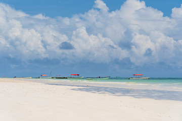 Tropical sand beach, clear sea water and blue sky with white clouds on the island of Zanzibar, Tanzania, Africa