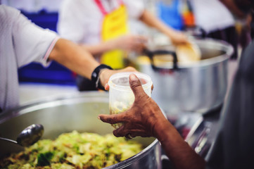 Hungry people are assisted with free charity food from volunteers.