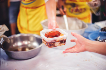 The concept of giving: Homeless people reach out to free volunteer meals from volunteers: help feed the hungry in society.