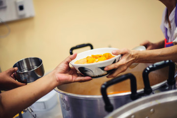 Starving homeless people receive food from volunteers who serve humane: the concept of giving with care