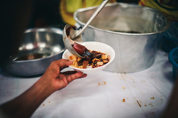 Starving homeless people receive food from volunteers who serve humane: the concept of giving with care