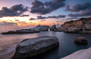 Rocky seashore seascape with dramatic and beautiful sunset at sea caves coastal area  in Paphos,...