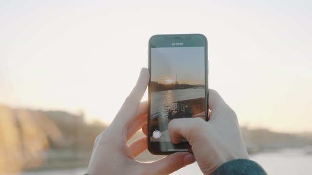 Amazing close-up, happy woman taking smartphone video of sunset over Eiffel Tower and Seine river in Paris slow motion.