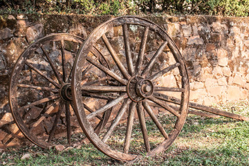 Fototapeta na wymiar wagon wheel parking on grass with stone wall background in Brazil