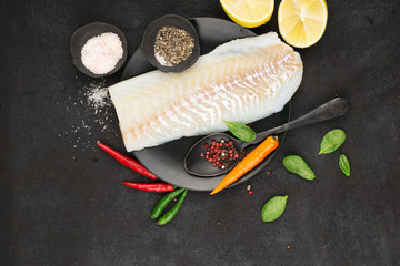 Fillet of white sea organic cod before cooking with minimal healthy food ingredients. Pure protein. Top view