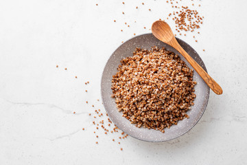 Tasty and healthy buckwheat porridge with butter on light grey background. top view