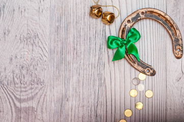 horseshoe, coins and bells on a light wooden table. A symbol of good luck. blank for designers