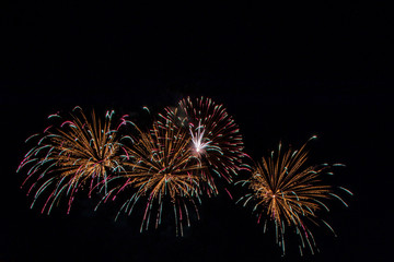 Multicolored bright festive fireworks in the dark sky background.Beautiful colorful fireworks for celebration holiday concept. 