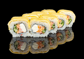 sushi and rolls with different fillings on a black background with reflection