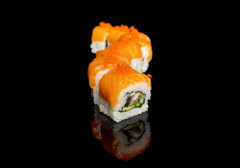 sushi and rolls with different fillings on a black background with reflection