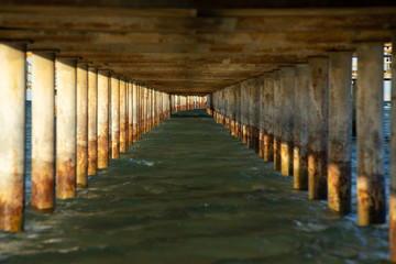 Obraz premium View under a jetty on a sunny evening. Focus far.