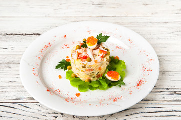 Fermented products in a restaurant close-up. Russian New Year's salad on a white plate and copy space. Meat salad with quail eggs.