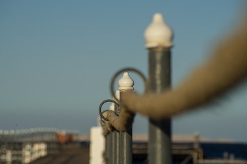 Rope railing of a landing stage in the evening light. Low angle,