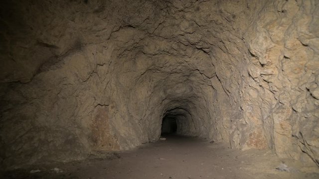 Speleology artificial cave dark tunnel excavation underground. Old adit for the extraction of metal and rocks