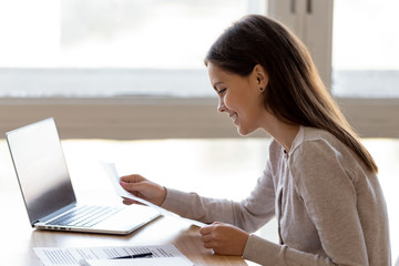 Smiling young woman read pleasant news in letter