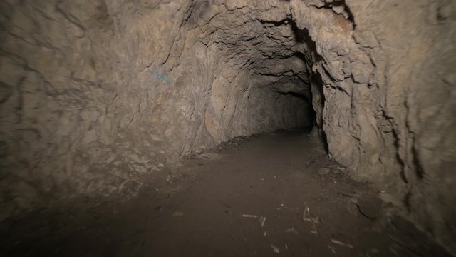 Speleology artificial cave dark tunnel excavation underground. Old adit for the extraction of metal and rocks