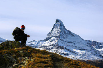 Matterhorn, Switzerland - October 16.2016: A young hiker taking a rest during trekking with the...