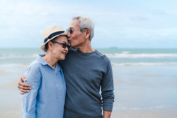 Kissing moment of asian couple senior elder retirement resting at beach honeymoon family together happiness people lifestyle, copy space the right