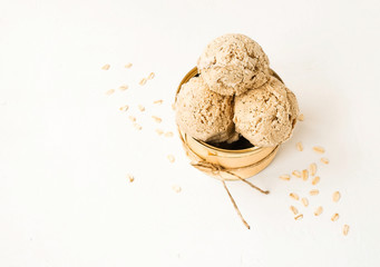 Oatmeal ice cream balls in a tin on a light background with space for text. Top view