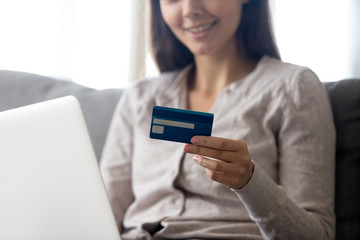 Close up of smiling girl hold credit card shopping online