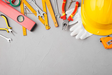 Flat lay composition with construction tools on light grey background. Space for text
