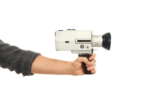Man with vintage video camera on white background, closeup of hand