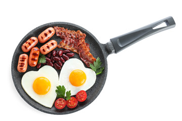Delicious breakfast with heart shaped eggs and sausages isolated on white, top view