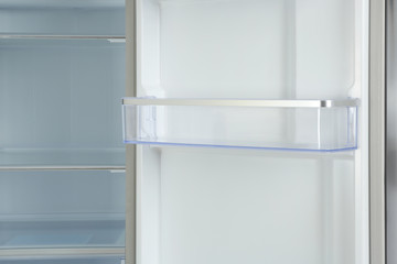 Door shelf of empty modern refrigerator, closeup view
