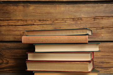 Collection of different books on table against wooden background