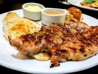 Closeup Pork and fish steak on a white plate.
