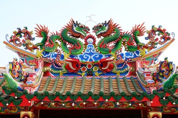 Dragon statue on Chinese temple roof with sky background 